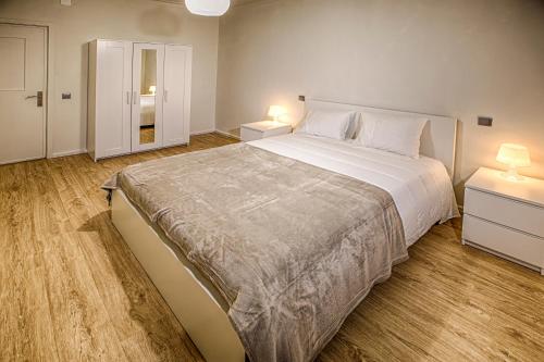 een slaapkamer met een groot bed en 2 nachtkastjes bij Aromas Flavors Tours - Apartment Velasquez in Porto