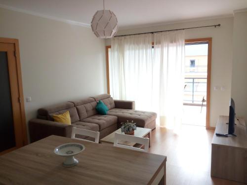 a living room with a couch and a table at Fun & Sun Apartment in Olhão