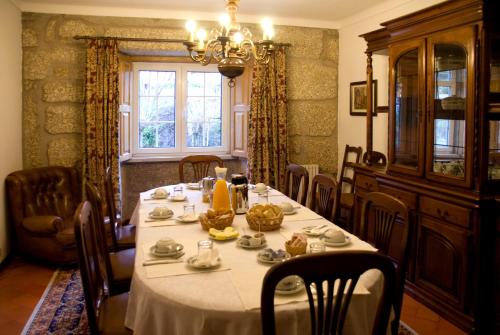 a dining room with a table and a chandelier at Casa da Ribeira in Alvoco da Serra