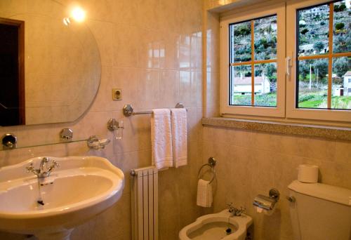 a bathroom with a sink and a toilet at Casa da Ribeira in Alvoco da Serra