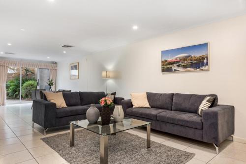 a living room with two couches and a table at Adelaide Style Accommodation-Close to City-North Adelaide-3 Bdrm- FREE Parking in Adelaide