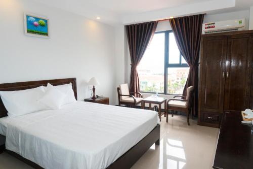 a hotel room with a bed and a window at Aries Hotel in Tuy Hoa