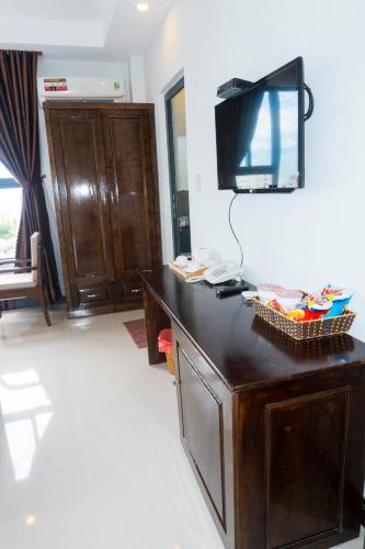 a room with a desk with a television on a wall at Aries Hotel in Tuy Hoa