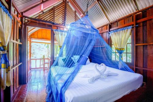 a bed that has a canopy over it at Khao Sok Palmview Resort in Khao Sok National Park