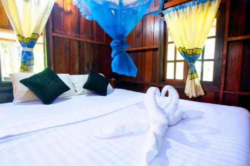 a bedroom with a bed with two swans on it at Khao Sok Palmview Resort in Khao Sok
