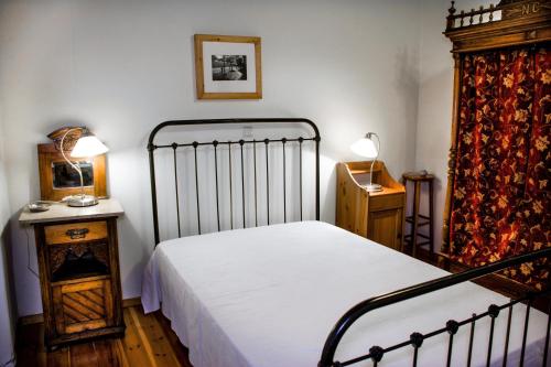 1 dormitorio con 1 cama, 1 mesa y 2 lámparas en Nostos Residence - Apartment Terra, en Tselendáta