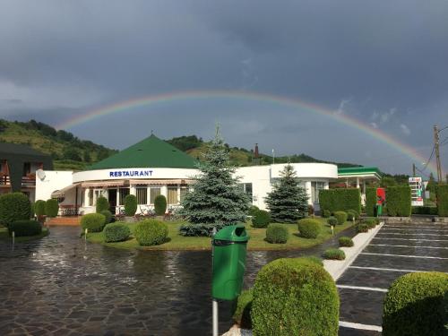 Un arcobaleno nel cielo sopra un edificio di Motel Sora a Sovata