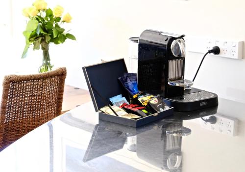 a desk with a computer on a glass table at Kahu Farm Apartment in Matakana