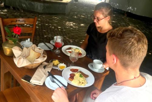 a woman and a man sitting at a table with food at Artisan Villa in Colombo