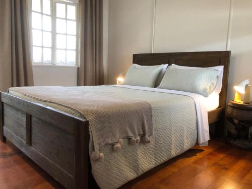 1 dormitorio con 1 cama grande con sábanas y almohadas blancas en Five 3 Five, en Hervey Bay