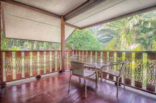 a porch with a table and chairs on a balcony at Khao Sok Palmview Resort in Khao Sok