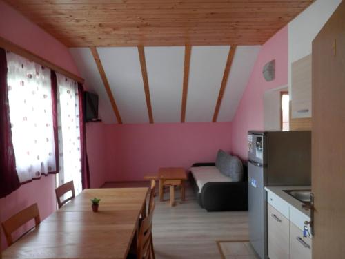 Guesthouse Matija في Irinovac: مطبخ وغرفة معيشة مع أريكة وطاولة
