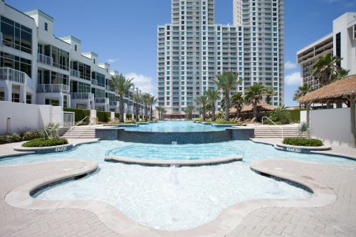 a large swimming pool in a resort with tall buildings at Sapphire in South Padre Island