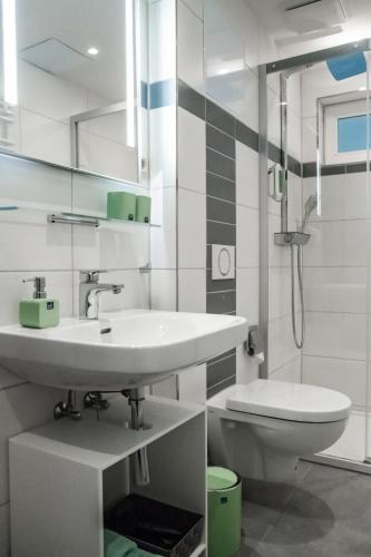 a white bathroom with a sink and a toilet at Altstadt-Apartment in Freiberg