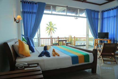 a bedroom with a bed with a view of the ocean at Sanmira Renaissance in Unawatuna