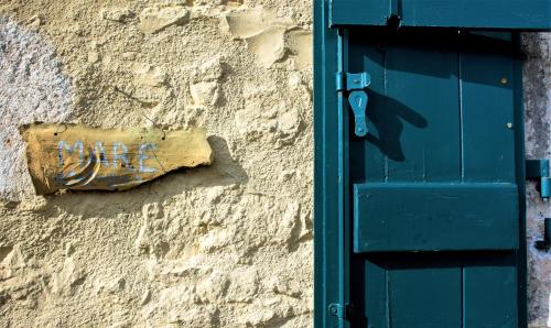 a sign on the side of a building next to a door at Nostos Residence - Apartment Mare in Matsoukáta