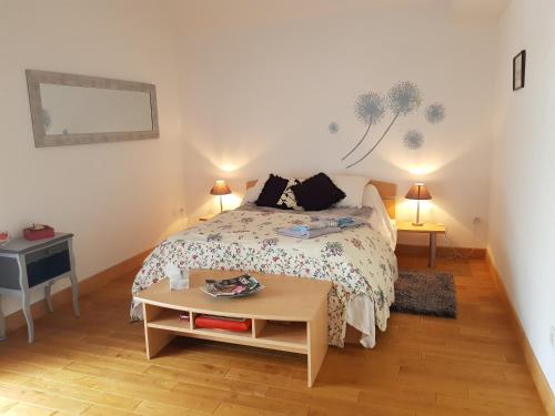 Dormitorio pequeño con cama y mesa en Le ptit Venton maison écologique pour particulier ou professionnel, en La Jaille-Yvon