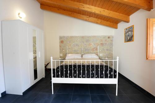 un letto bianco in una camera con soffitto in legno di Al Giardino di Anna a Fondi