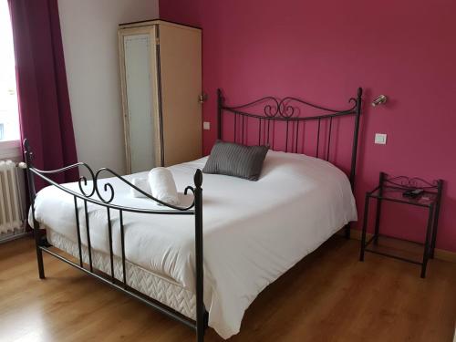 MontcuqにあるHôtel La Barguelonneの赤い壁のベッドルーム1室