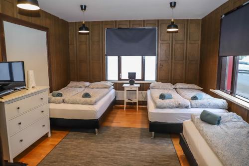 sypialnia z 2 łóżkami, telewizorem i kanapą w obiekcie Lava Guesthouse w mieście Vestmannaeyjar