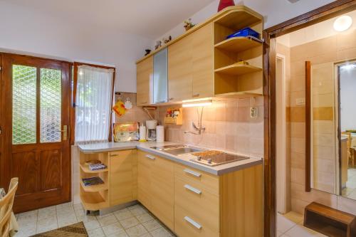 una cucina con armadi in legno e lavandino di Apartments Beba a Mali Lošinj (Lussinpiccolo)