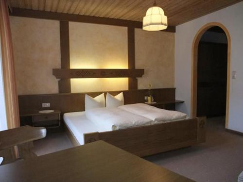 Haus Kirschner في يرتسنز: غرفة نوم بسرير وطاولة ومصباح