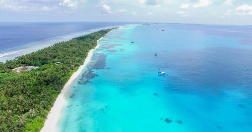 an aerial view of a beach with a boat in the water at Dhiguveli Maldives in Dhigurah