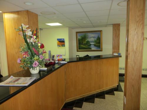 a reception desk in a waiting room with flowers on it at Chinatown Hotel Chicago in Chicago