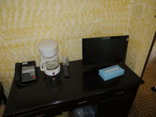 a black desk with a coffee maker and a tv at Chinatown Hotel Chicago in Chicago