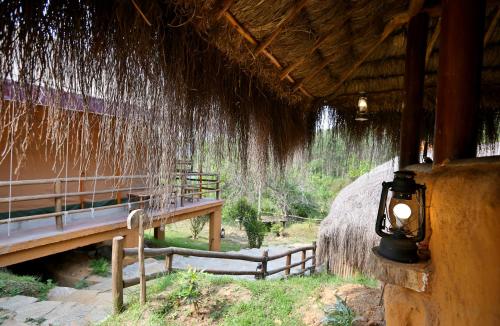 a light on the side of a building with a bench at Deshadan Eco Valley Resort - An Eco friendly Mud House in Kanthalloor