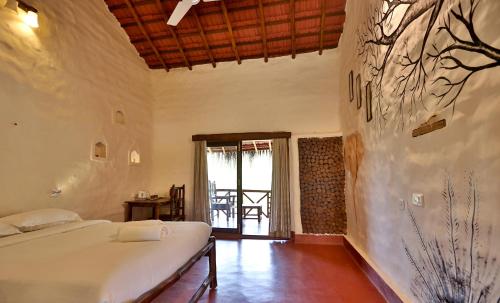 a bedroom with a bed in a room at Deshadan Eco Valley Resort - An Eco friendly Mud House in Kanthalloor