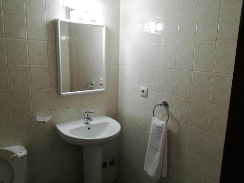 Baño blanco con lavabo y espejo en Hotel l'Albera en La Jonquera