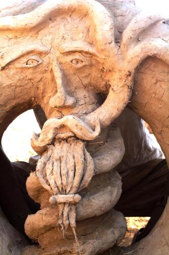 a statue of a face made out of wood at Desert Days mud cabin's Resort in Zuqim
