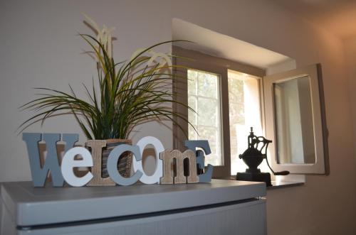 a sign on top of a dresser with a plant on it at Casa di Meo in Buti