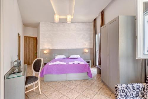 a bedroom with a purple bed and a table at Ethrion in Ermoupoli