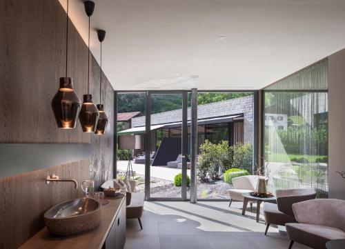 a living room with a sink and a large window at Klein Fein Hotel Anderlahn in Parcines