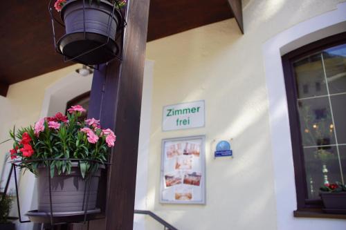 a potted plant on a pole next to a building at Hotel Deutsches Haus Anno 1898 in Sonthofen