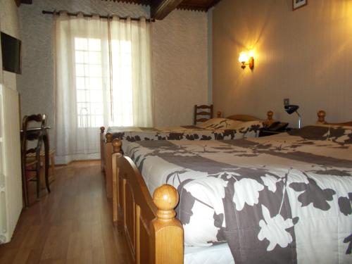 a bedroom with two beds and a window at Hotel Chaumiere - in Tournon-sur-Rhône