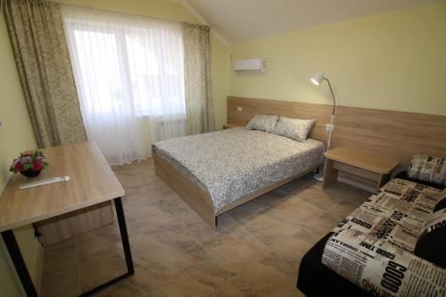 ブラゴヴェシェンスカヤにあるГостевой дом Черноморская 8Аのベッドルーム1室(ベッド1台、テーブル、窓付)