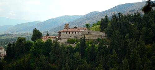 an old building on the side of a mountain at River Side Rooms in Elassona