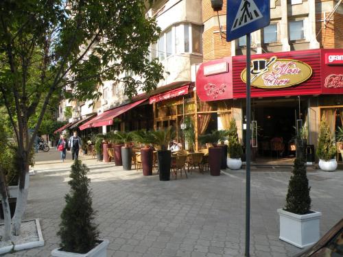 a street with tables and chairs in front of buildings at GrandVille Apartments in Bucharest