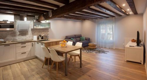 cocina y sala de estar con mesa y sillas en Precioso apartamento al lado de la Catedral, en Burgos