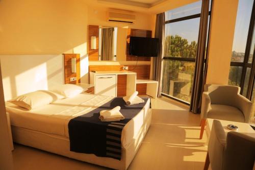 a bedroom with a bed and a large window at Çeşme Farm Hotel in Çeşme