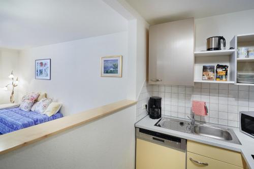 a small kitchen with a bed and a sink at Ferienwohnung Südschwarzwald in Bräunlingen