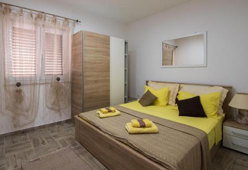 1 dormitorio con cama con almohadas amarillas y ducha en Srima Angel´s Apartments en Vodice