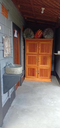 a bathroom with a sink and a wooden cabinet at Black Lava Hostel and Lodge in Kintamani