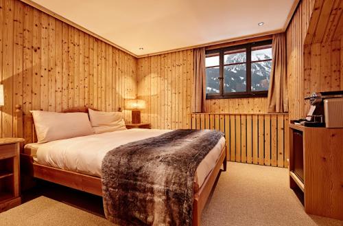 a bedroom with a bed and a window at Hotel Sanetsch in Gsteig