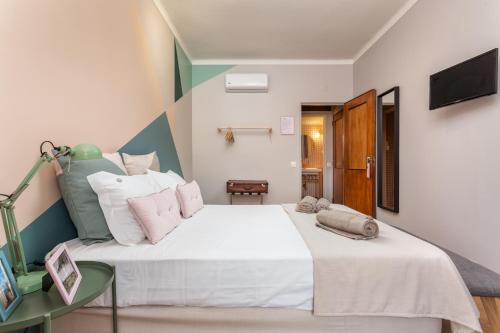 a bedroom with a large white bed and a table at Casas da Formosa - Downtown Alegria in Tavira