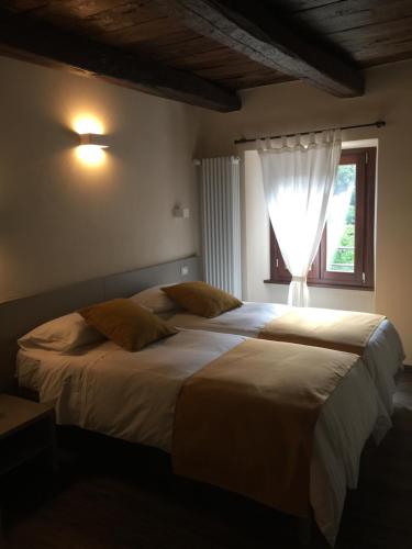 2 camas en un dormitorio con ventana en Delzanno, en Varallo