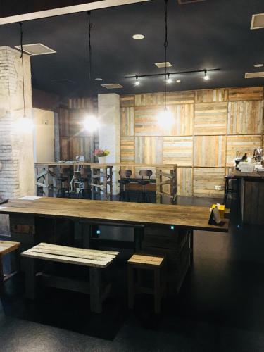 a large wooden counter in a restaurant with benches at Guesthouse Masago in Urakawa